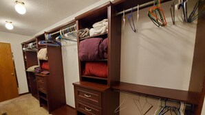 En rymlig klädkammare med flera hyllor, lådor och plats för att hänga upp kläder och förvara accessoarer.