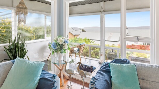 A bright room with large windows, a glass table, and a view of the outdoors. - Luxury Heritage Cottage with Harbour Views in Albany (Albany)