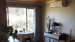 A kitchen with a wooden ceiling, a dining area with a table and chairs, and a view of trees outside. - "Get away from the world for a while" (Macclesfield)