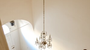 Un escalier avec une rampe en bois et un lustre suspendu au plafond.