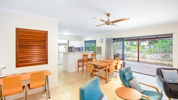 Un soggiorno moderno con zona pranzo, cucina e patio con vista sull'esterno.