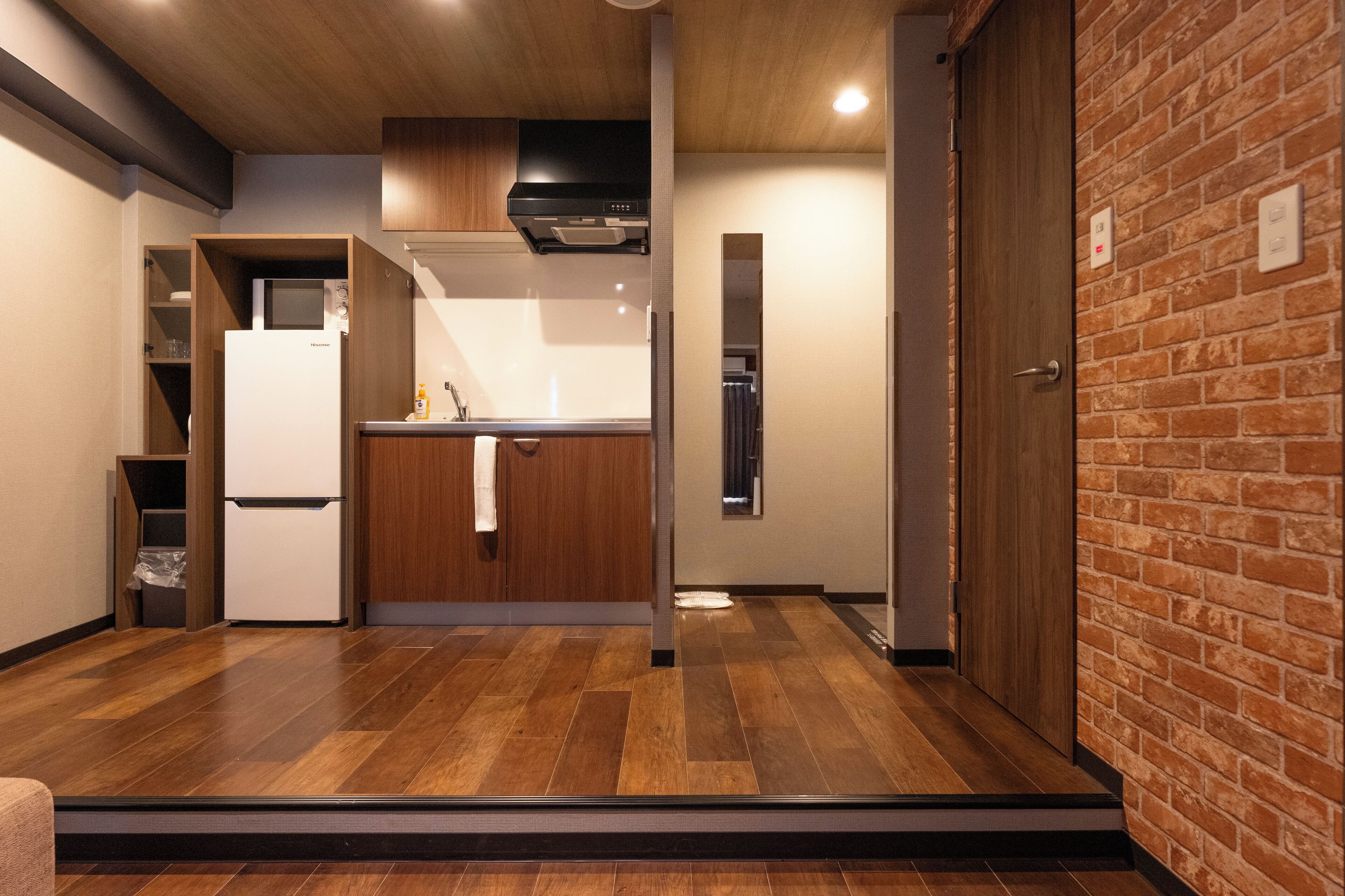 A modern kitchen with wooden cabinets, a built-in oven, and a stainless steel range hood.