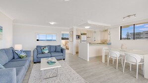 Un appartement moderne comprenant un salon, un coin repas et une cuisine.