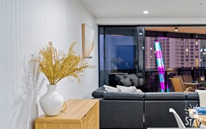 Relax in a stylish living room with a sofa, glass partition, and city view.