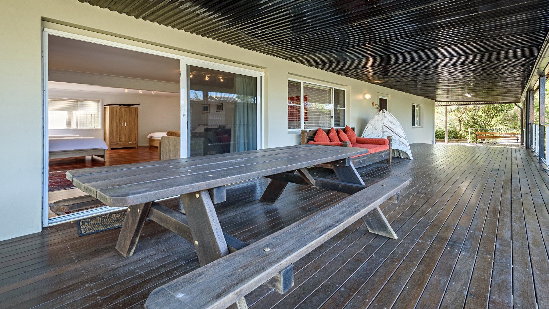 Un espacio al aire libre techado con una mesa de picnic de madera y asientos.