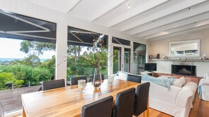 Enjoy meals in the dining area overlooking lush greenery and the ocean.