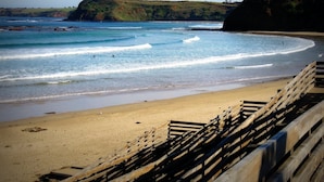 A beach with wooden railings, waves, and a distant hill. - Mills Court, Quirky seaside house at Smiths Beach, bring the surf boards! (Smiths Beach)