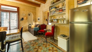 Una cocina acogedora con techo de madera, un comedor con mesa y sillas, un sofá y un refrigerador.