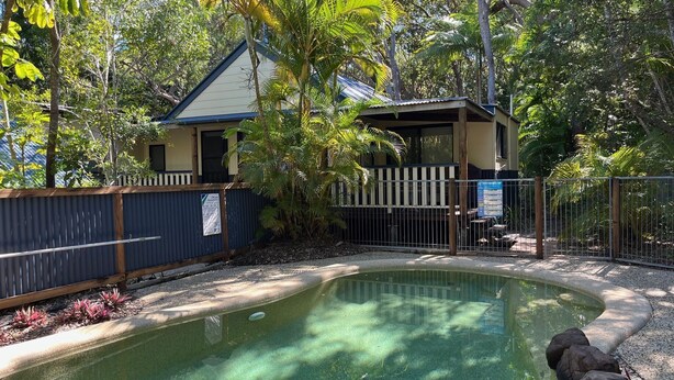 A pool surrounded by a wooden fence, with a building in the background. - 8 Orania Court - Rainbow Shores. Privacy, Peace and Quiet (RAINBOW BEACH)