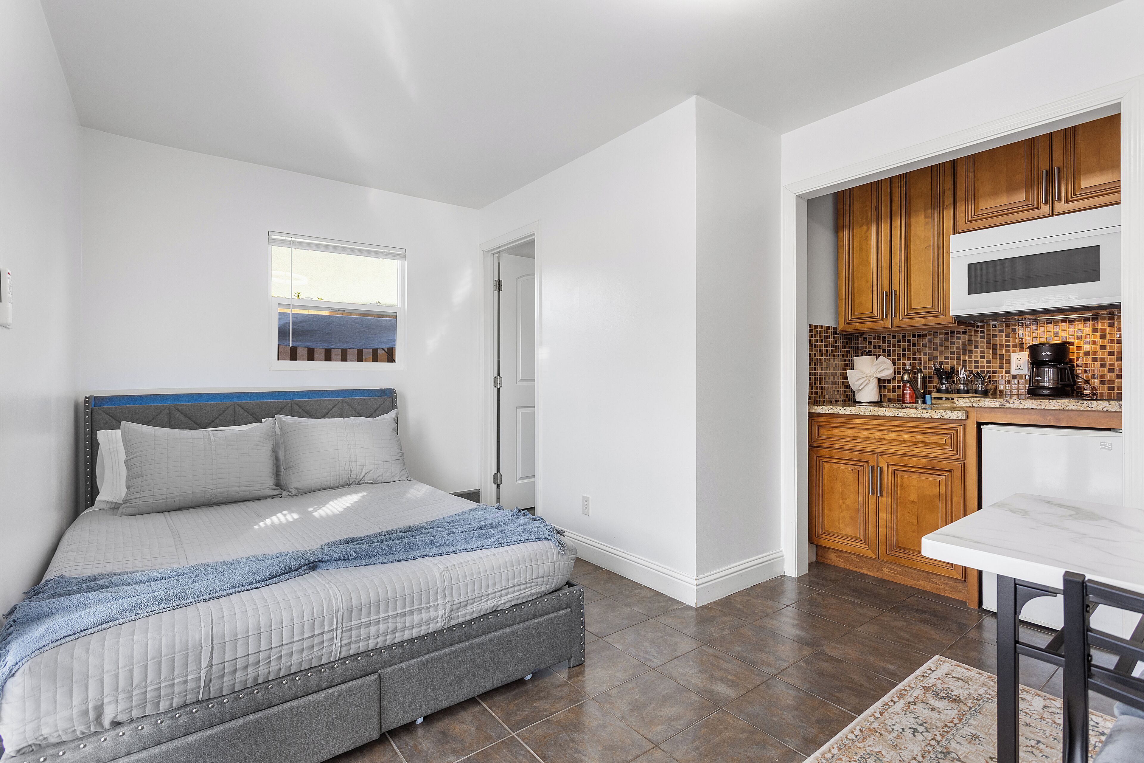 Un dormitorio con una cama, una mesita de noche y una ventana.