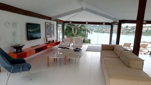 Una sala de estar moderna con sofá, sillones, una mesa de centro y televisor.