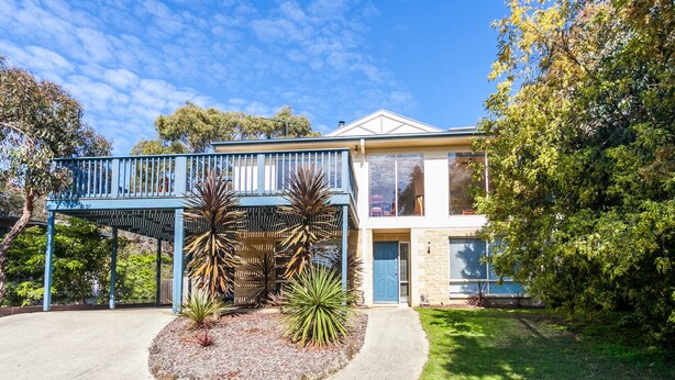 A two-story house with a covered porch and a well-maintained garden.