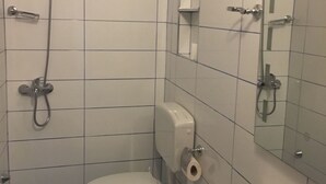 A bathroom with a toilet, bidet, sink, and a mirror. - Guesthouse Altin (Berat)