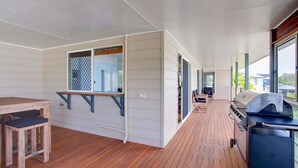 A modern kitchen with a wooden countertop, a built-in grill, and a window overlooking the deck. - 29 Cypress Avenue - Rainbow Beach. Close to the beach with a pool (RAINBOW BEACH)
