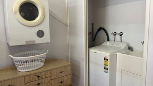 A laundry room with a washing machine, a dryer, and a sink. - Baker - Rainbow Beach. Walk to Everything! Including the beach and main street. (Rainbow Beach)