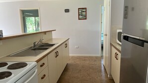 A kitchen with a stove, sink, and refrigerator. - Baker - Rainbow Beach. Walk to Everything! Including the beach and main street. (Rainbow Beach)