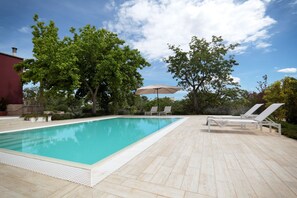 Una piscina al aire libre de temporada, sombrillas