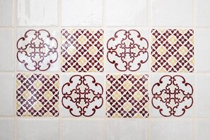 A wall with a grid of decorative tiles featuring floral patterns. - Villa Aurelia (Castellana Grotte)