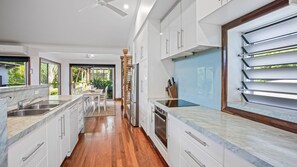 Enjoy cooking in this well-equipped kitchen with a central island, oven, and large window.
