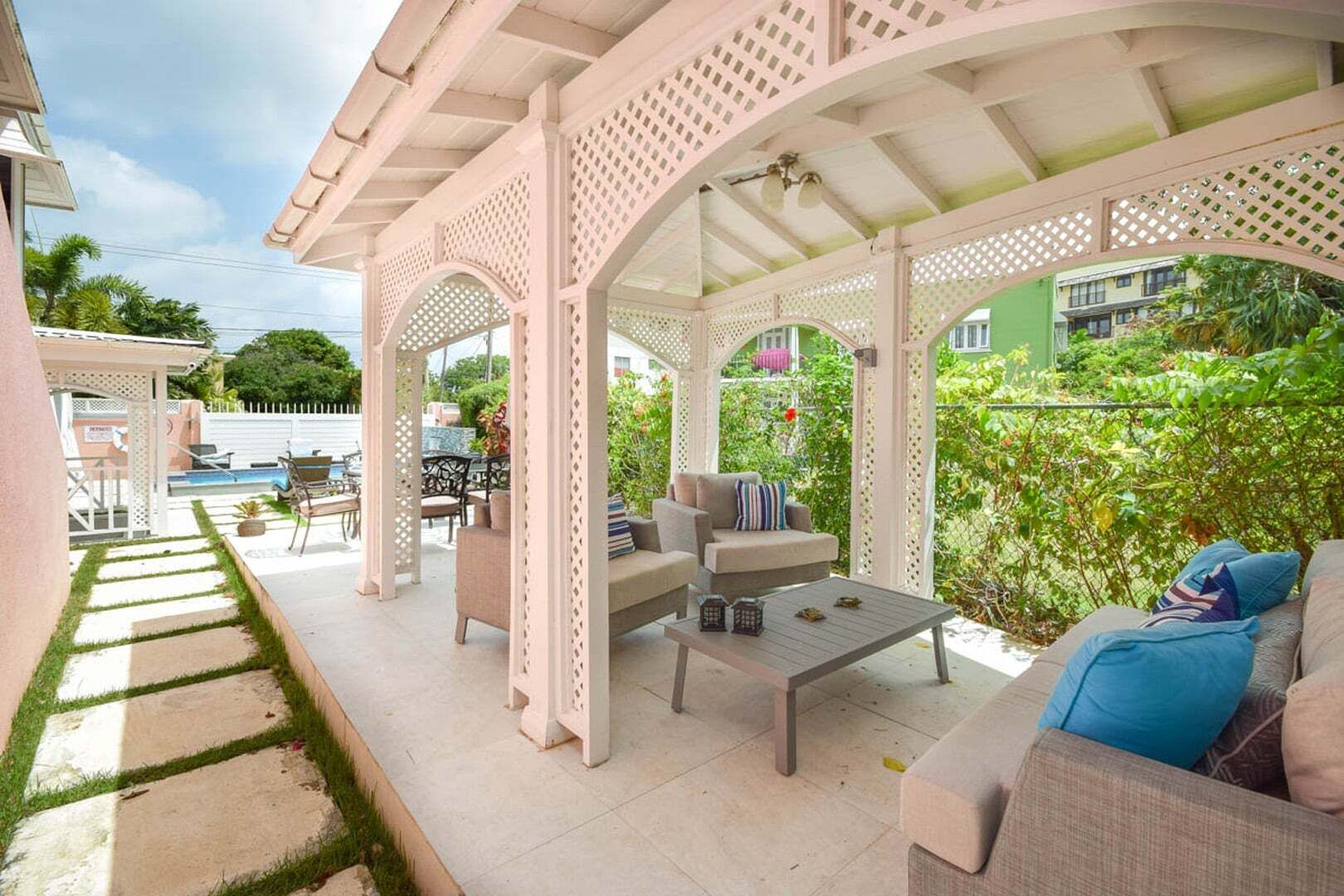 Un patio extérieur abrité, doté d’une piscine, d’un espace salon et offrant une vue sur un bâtiment écologique.