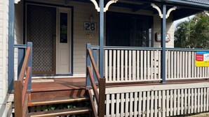 Een gebouw met een veranda, een bord met het nummer '28' en een bord met de tekst 'Holiday Letting'.
