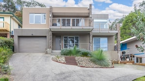 A modern two-story house with a garage, a balcony, and a landscaped front yard. - Craiglee (Lorne)
