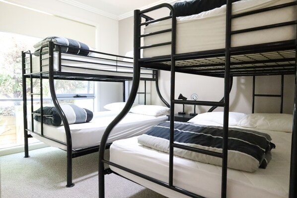 A bunk bed room with two beds, a window, and a nightstand. - Craiglee (Lorne)