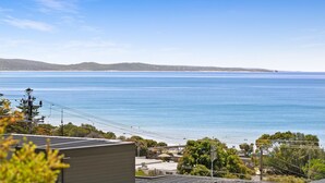A coastal view with a clear sky, a calm sea, and distant hills. - Fernview (Lorne)