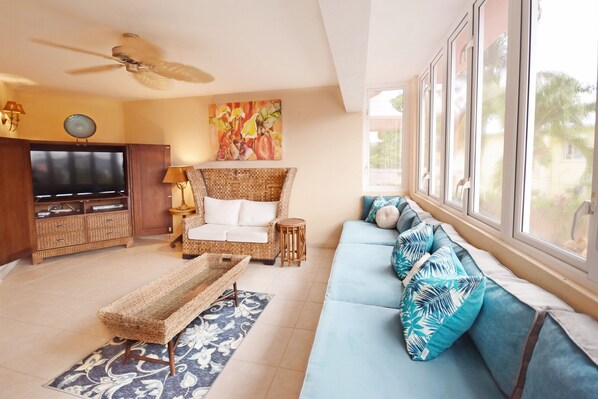 A living room with a television, sofa, and a ceiling fan. - 3 Min Walk to Beach - Blessed Manor (4 Bed House) (Hastings)