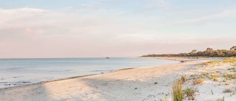 Een strand met een zandstrand en een kalme zee.