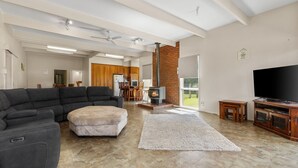 Uma sala de estar moderna com sofá seccional, televisão de tela plana e lareira.