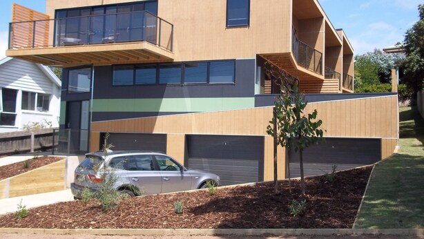 Uma casa moderna de dois andares com varanda, garagem e entrada para carros.