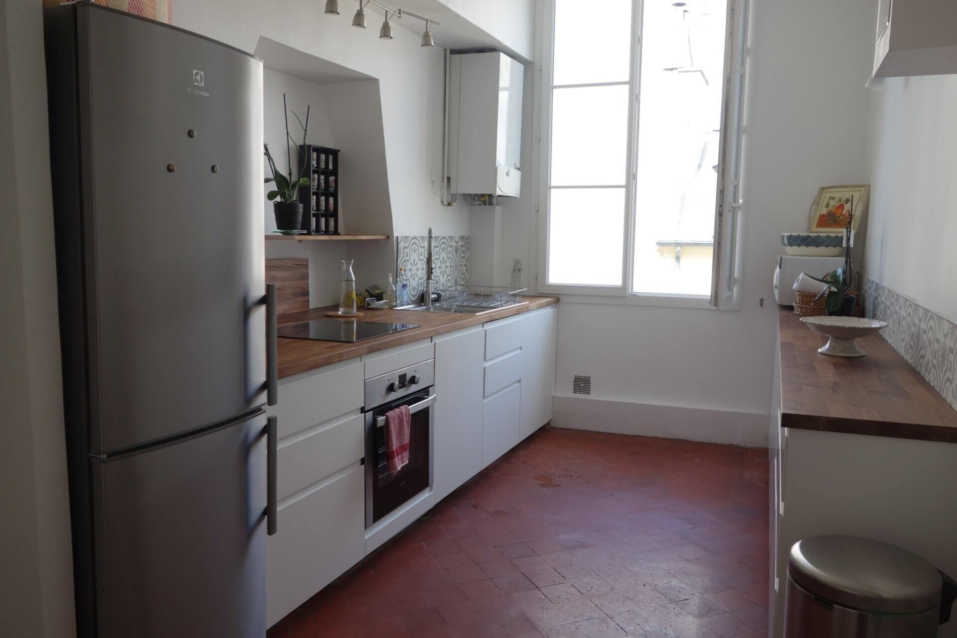 Una cucina con frigorifero, forno, lavello e una finestra.