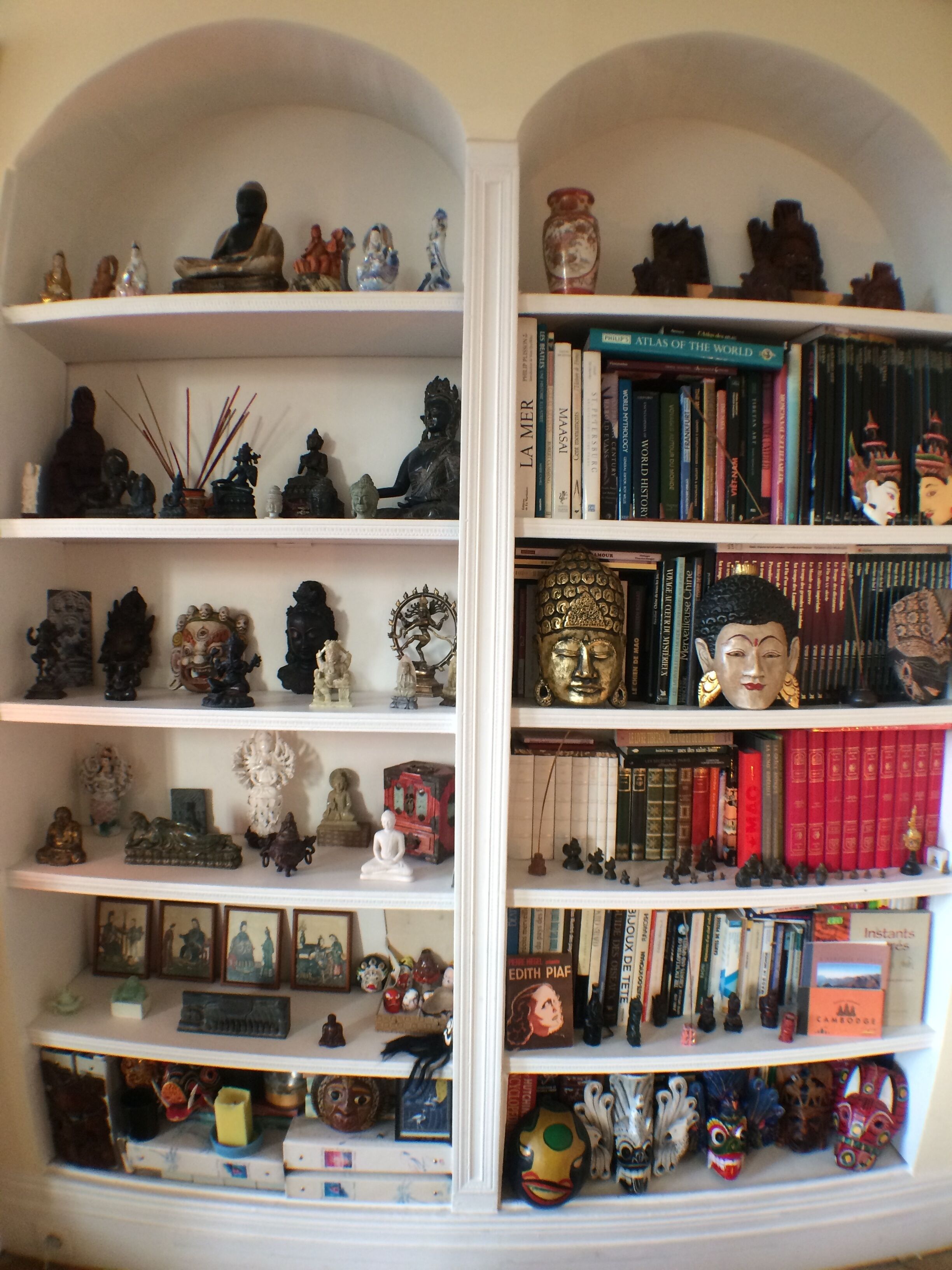 A bookshelf filled with books, figurines, and decorative items.