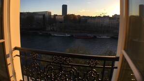 A view from a balcony overlooking a river with boats, buildings, and a clear sky. - Paris-sur-seine-chez-caroline (Paris)