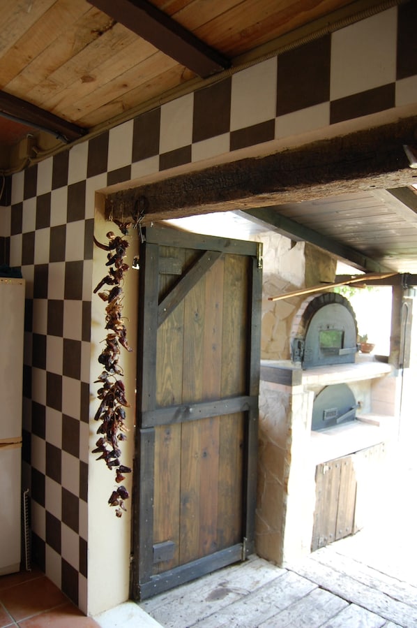 Ein Muster aus Schachbrettfeldern an der Wand, eine Holztür und eine Steinmauer mit einem Fenster.