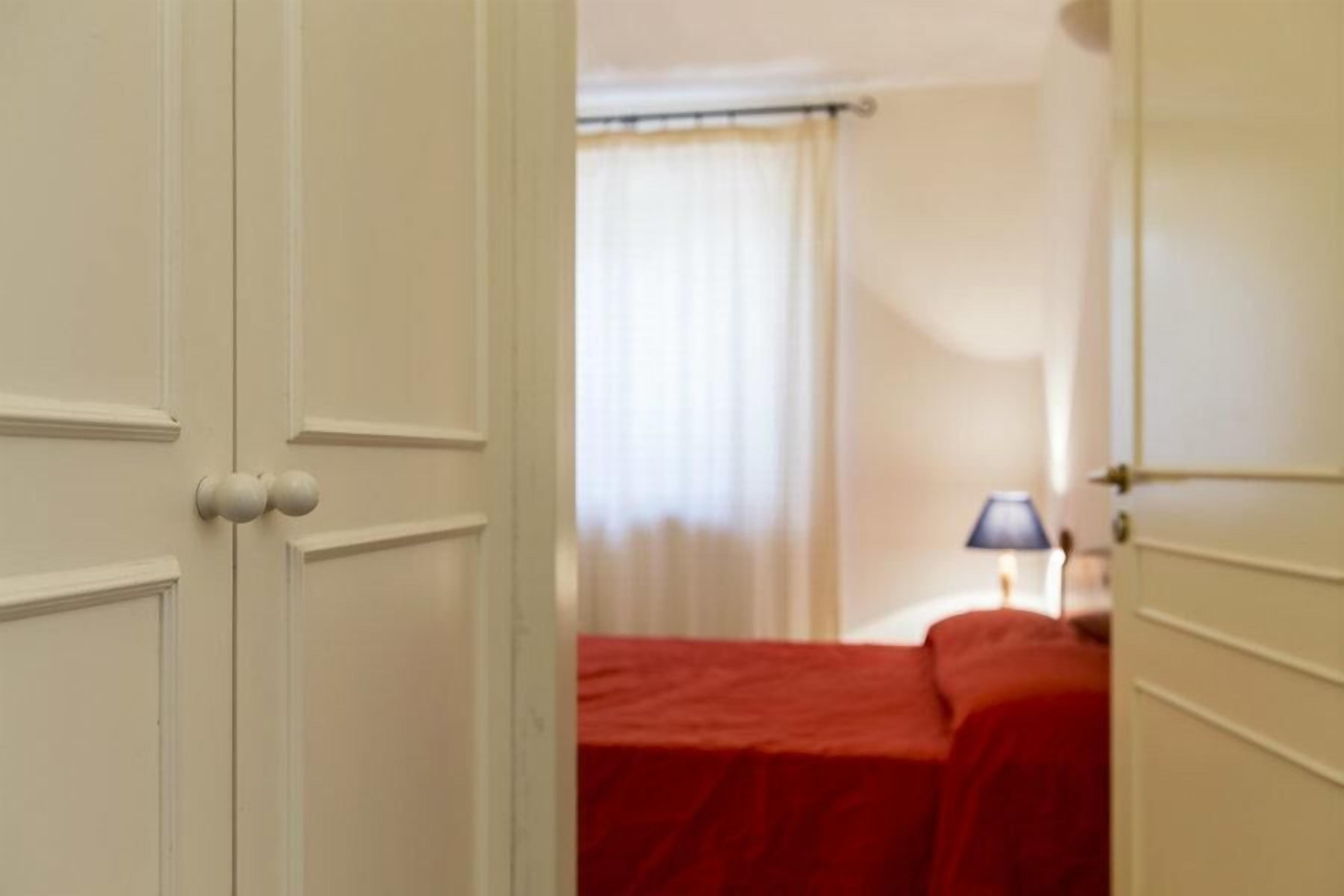 Een kamer met een bed, nachtkastje en lamp.