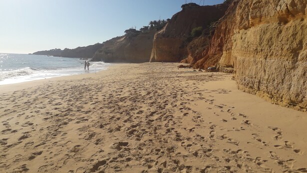 A sandy beach with footprints, a rocky cliff, and the ocean. - 2 Bedrooms, Beach at 300m, Parking (Albufeira)