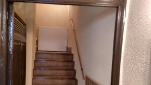Una escalera de madera con un marco decorativo de metal en la parte superior.