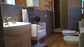 Een douche, een haardroger, een bidet, handdoeken
