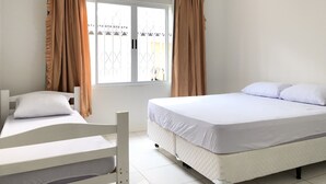 A room with two beds, a window with curtains, a ceiling fan, and a view of the outside. - House nearby SEA with pool in Balneário Camboriú  (Pioneiros)