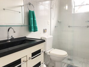 Features a bathtub, toilet, and shower enclosure.
