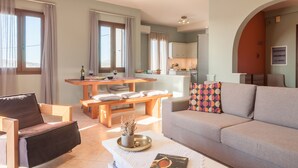 Una sala de estar moderna con un sofá, una mesa de comedor y una zona de cocina al fondo.