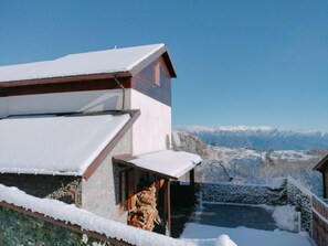 Un bâtiment enneigé offrant une vue dégagée sur un paysage montagneux.