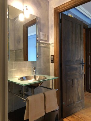 A bathroom with a glass sink, a mirror, and a wooden door. - RURAL HOUSE HORMILLA IN LA RIOJA (Hormilla)