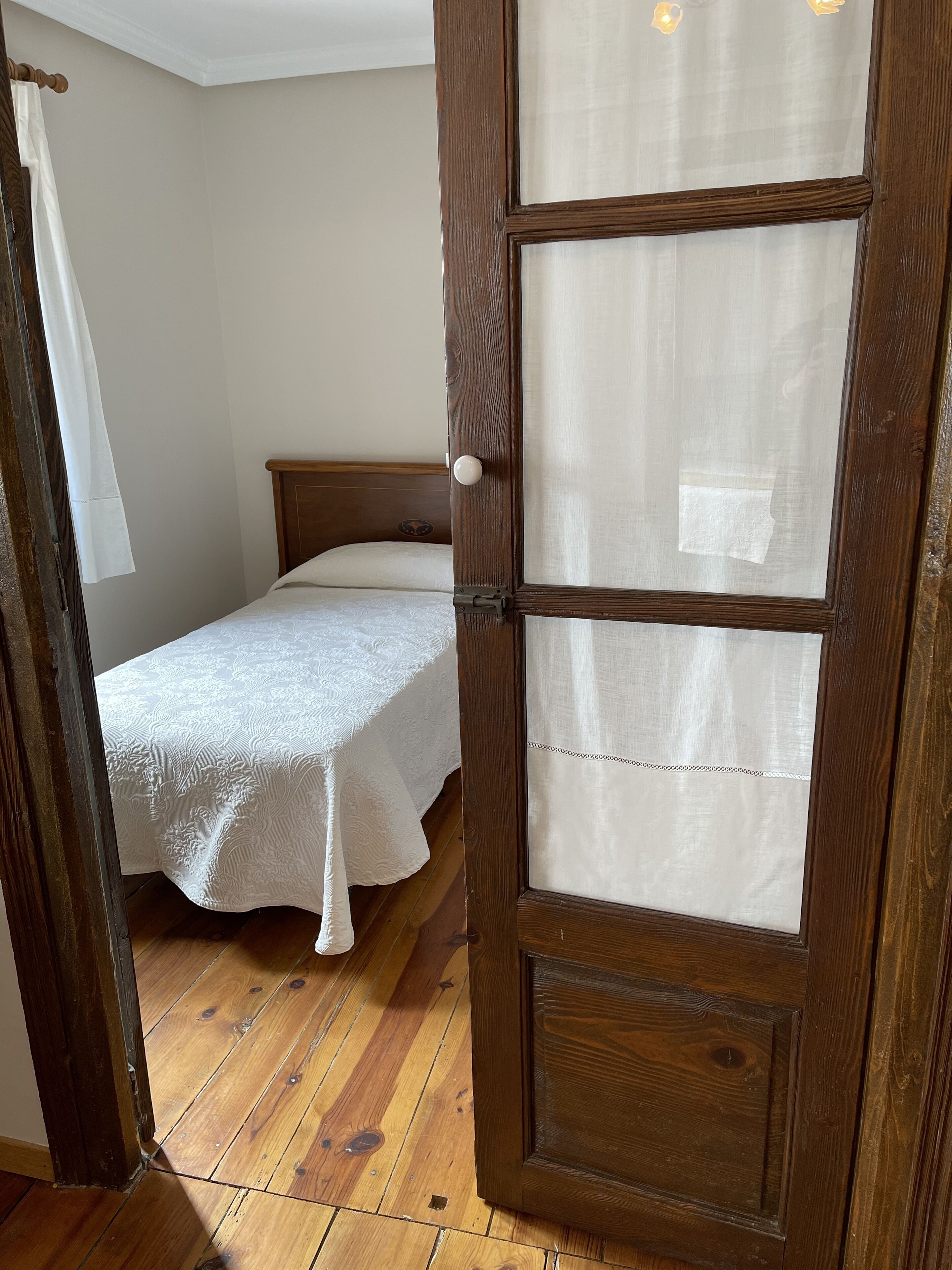 A wooden door with a frosted glass panel and a white doorknob.