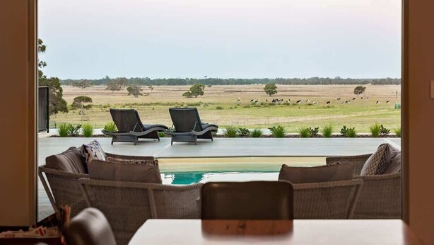 Quarto com vista para um campo gramado e uma piscina.
