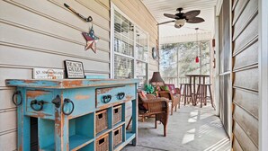 A porch with a blue cabinet, wicker furniture, and a ceiling fan. - Fully Furnished 3 bedroom condo close to the beach and pier (Saint Simons Island)