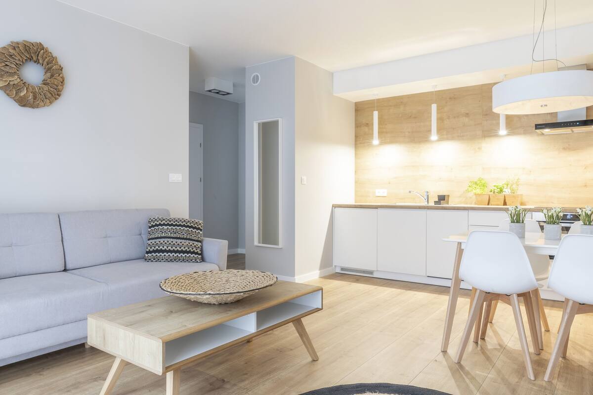Una sala de estar moderna con un sofá, una mesa de centro y un comedor con sillas.
