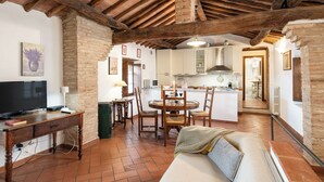 Una cocina rústica con vigas de madera, una mesa y sillas.